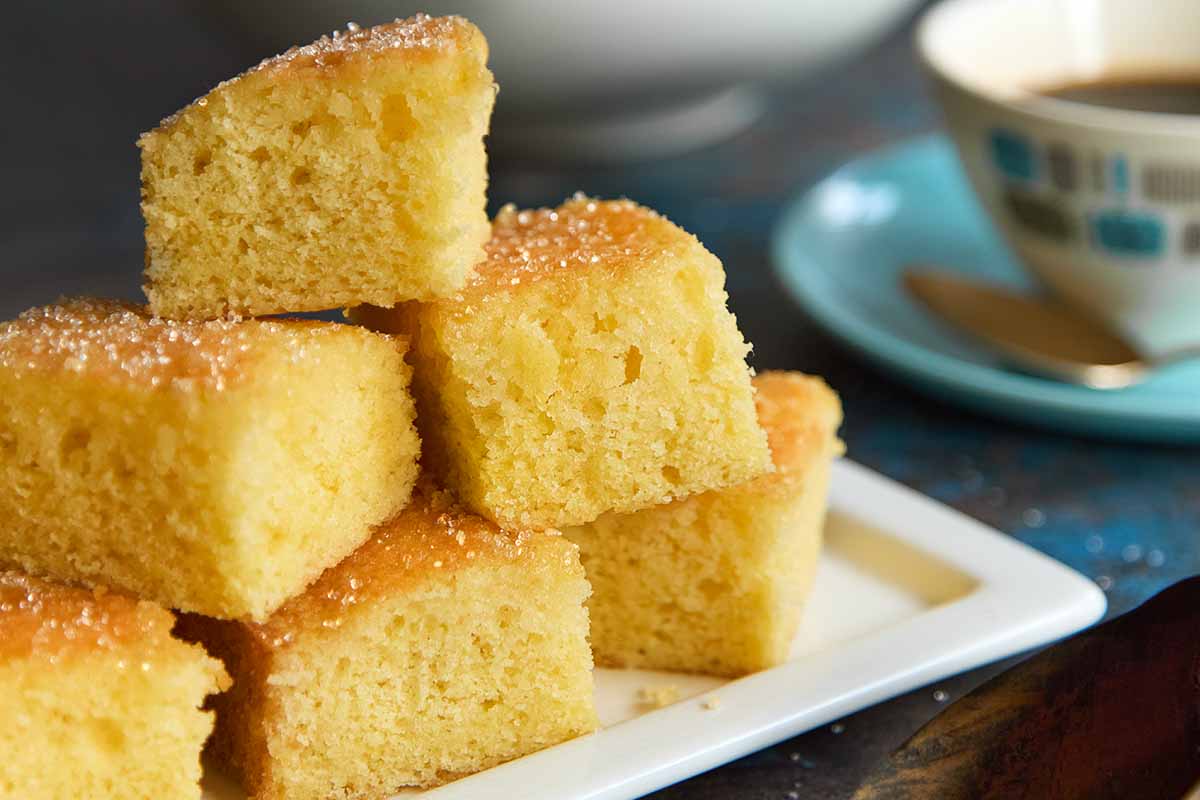 Golden lemon drizzle cake slices on a white plate